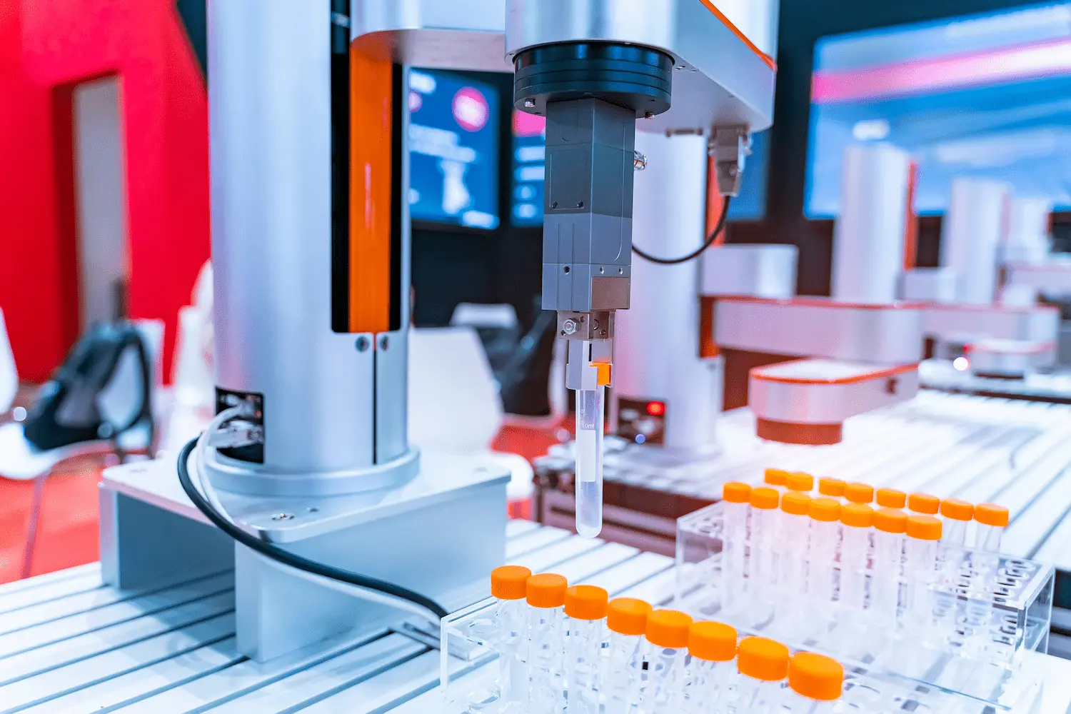 Automated robotic arm with a test tube at a laboratory workstation, surrounded by racks of capped test tubes.